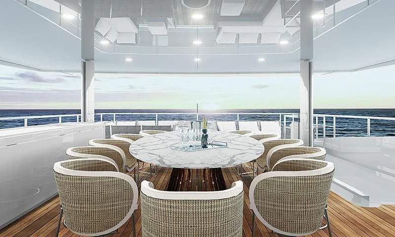 a table set with chairs and a large body of water in the background aboard LION Yacht for Sale