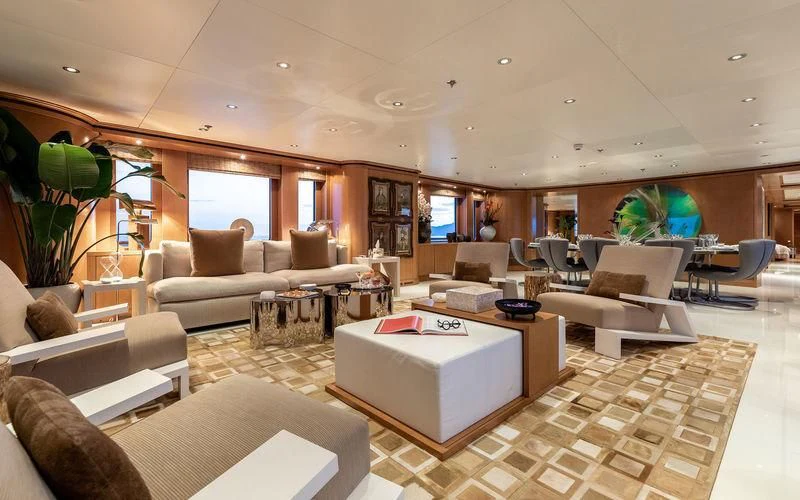a living room with a large white table and a large window aboard TREEHOUSE Yacht for Sale