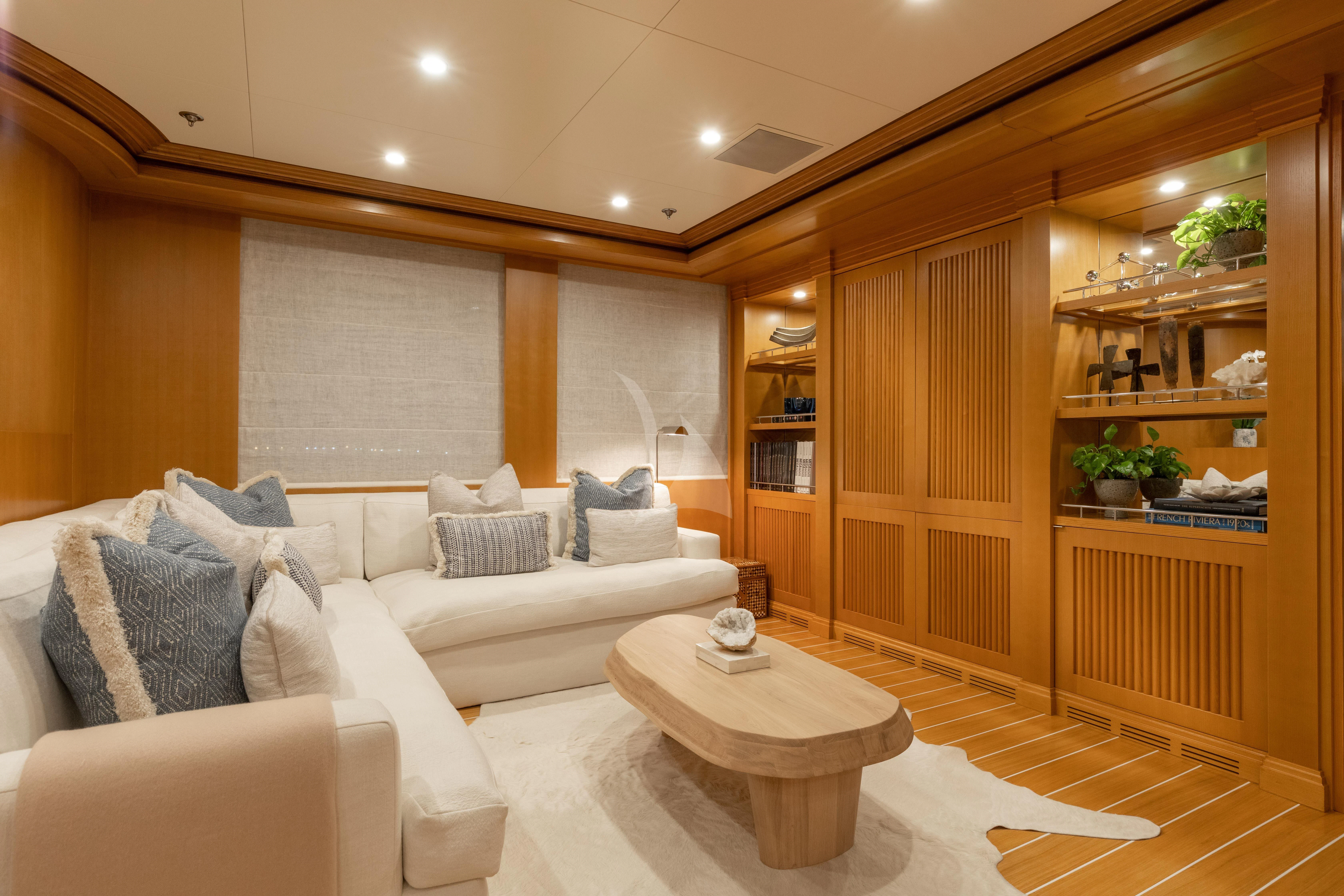 a living room with a white couch and a wood cabinet aboard TREEHOUSE Yacht for Sale