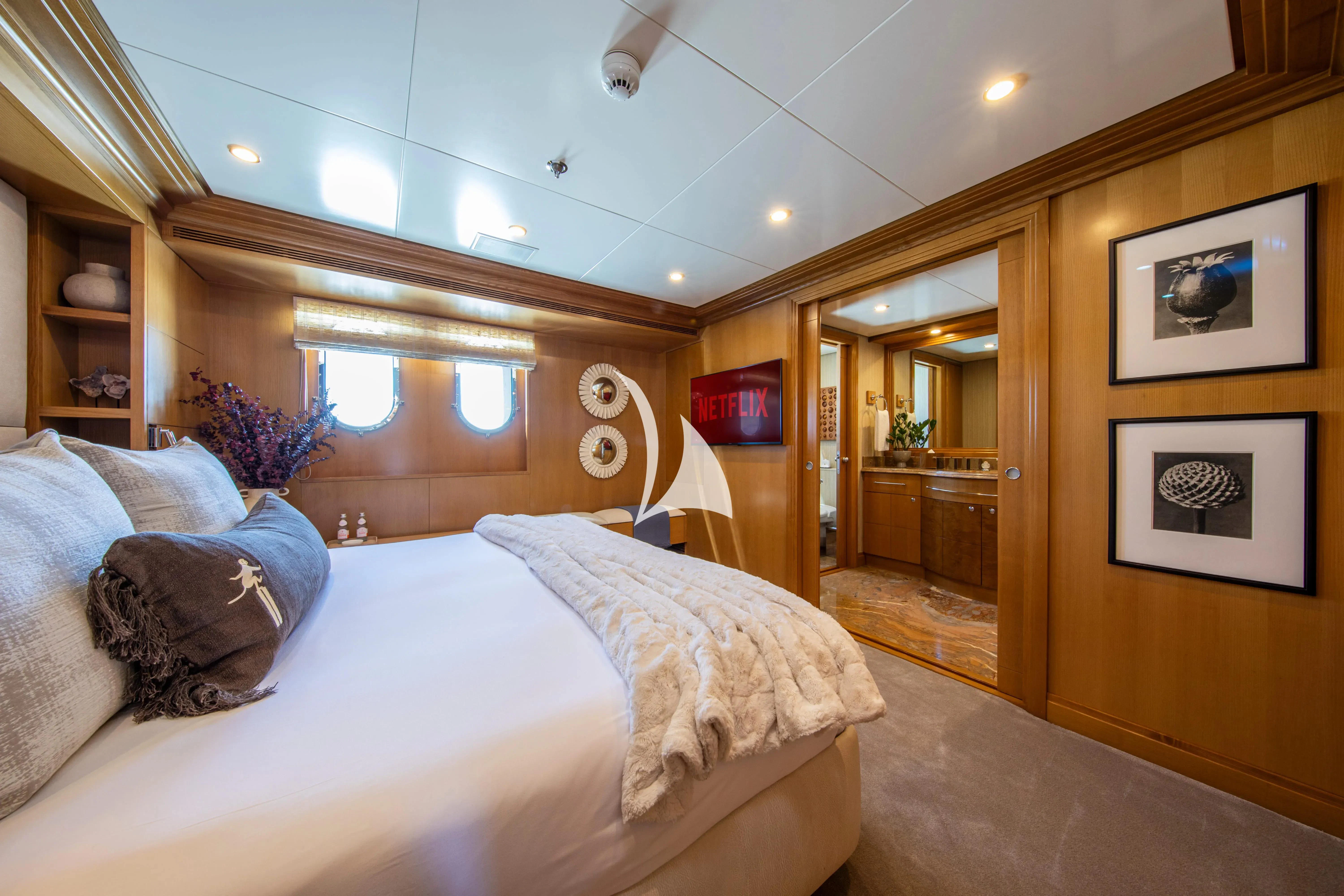 a bedroom with a bed and a mirror aboard TREEHOUSE Yacht for Sale