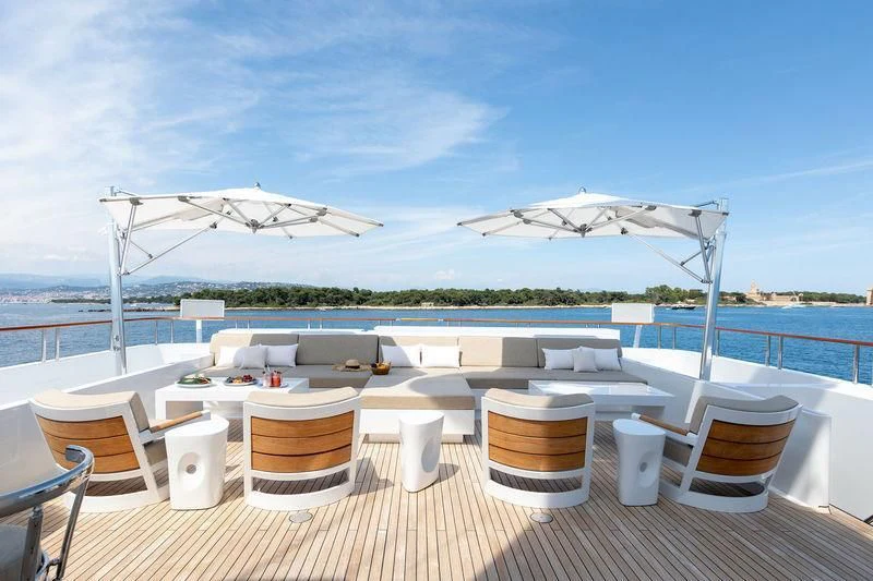 a table with chairs and umbrellas on it by a body of water aboard TREEHOUSE Yacht for Sale