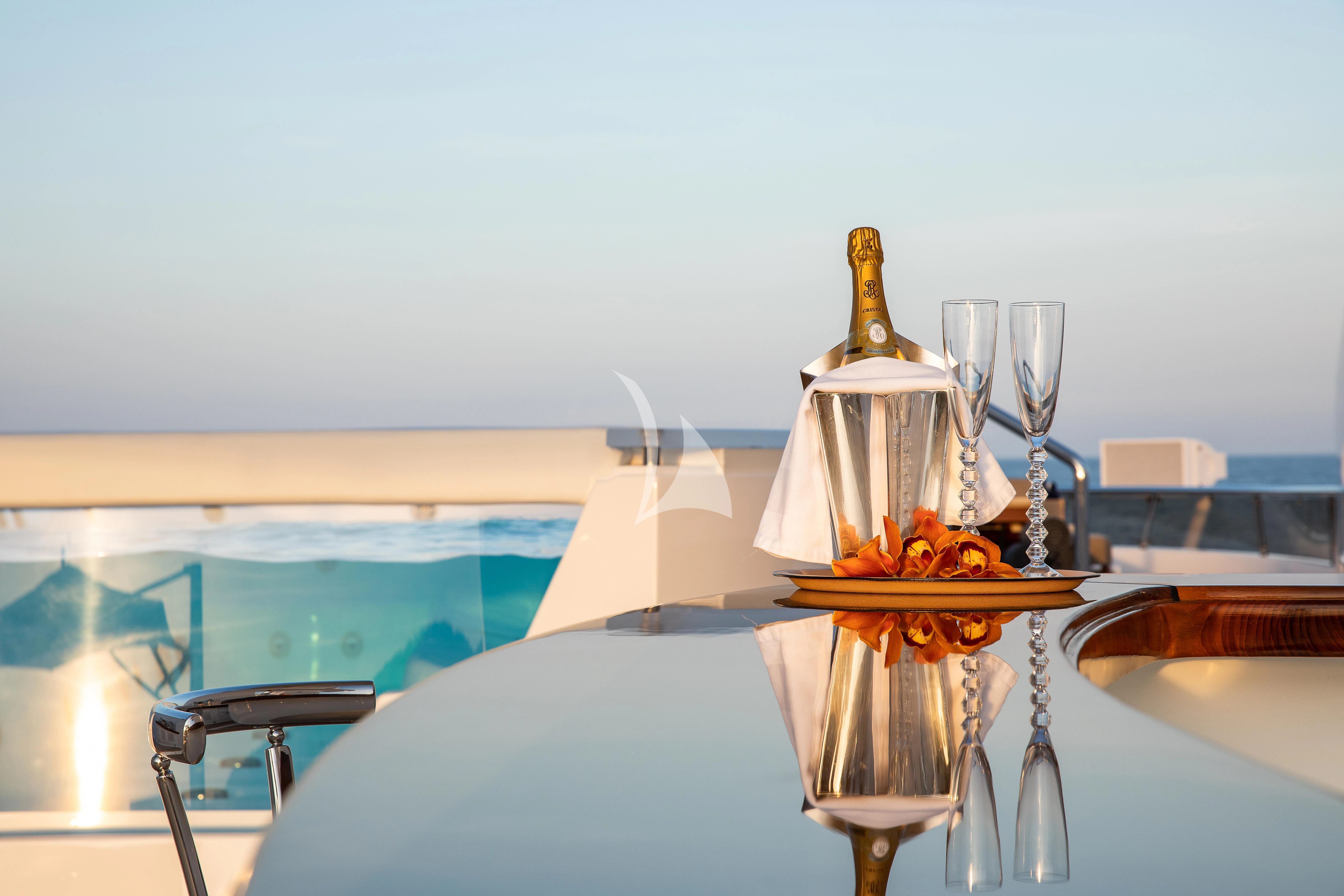 a glass of champagne with orange flowers aboard TREEHOUSE Yacht for Sale
