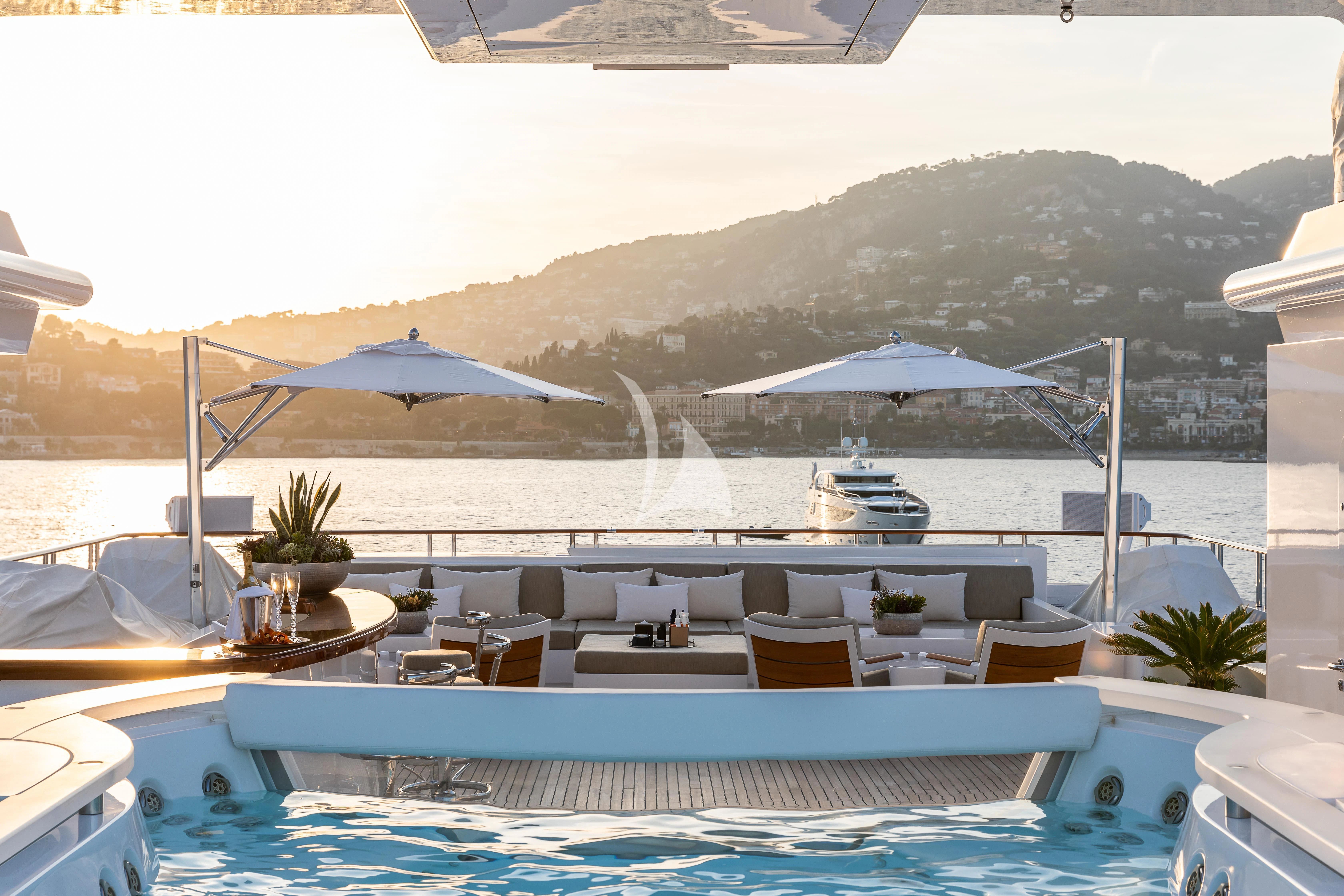 a swimming pool with lounge chairs and umbrellas aboard TREEHOUSE Yacht for Sale