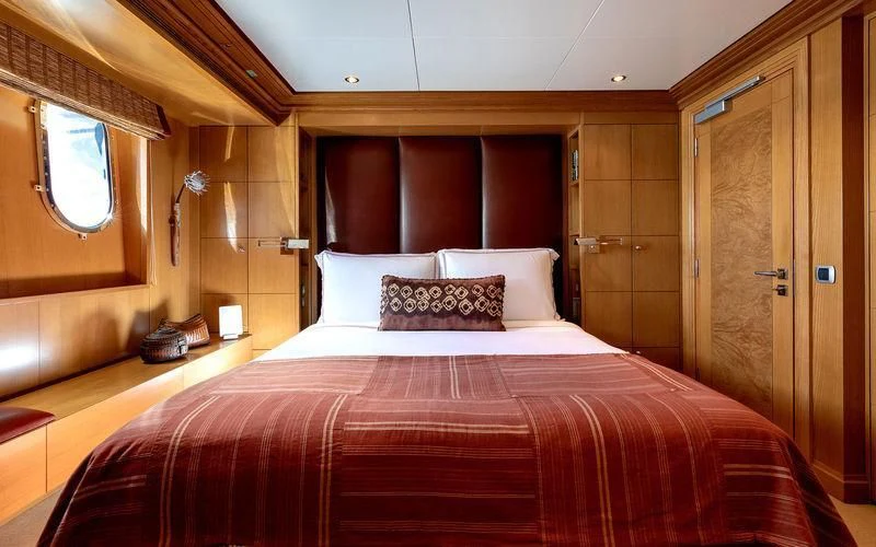 a bed with red sheets aboard TREEHOUSE Yacht for Sale