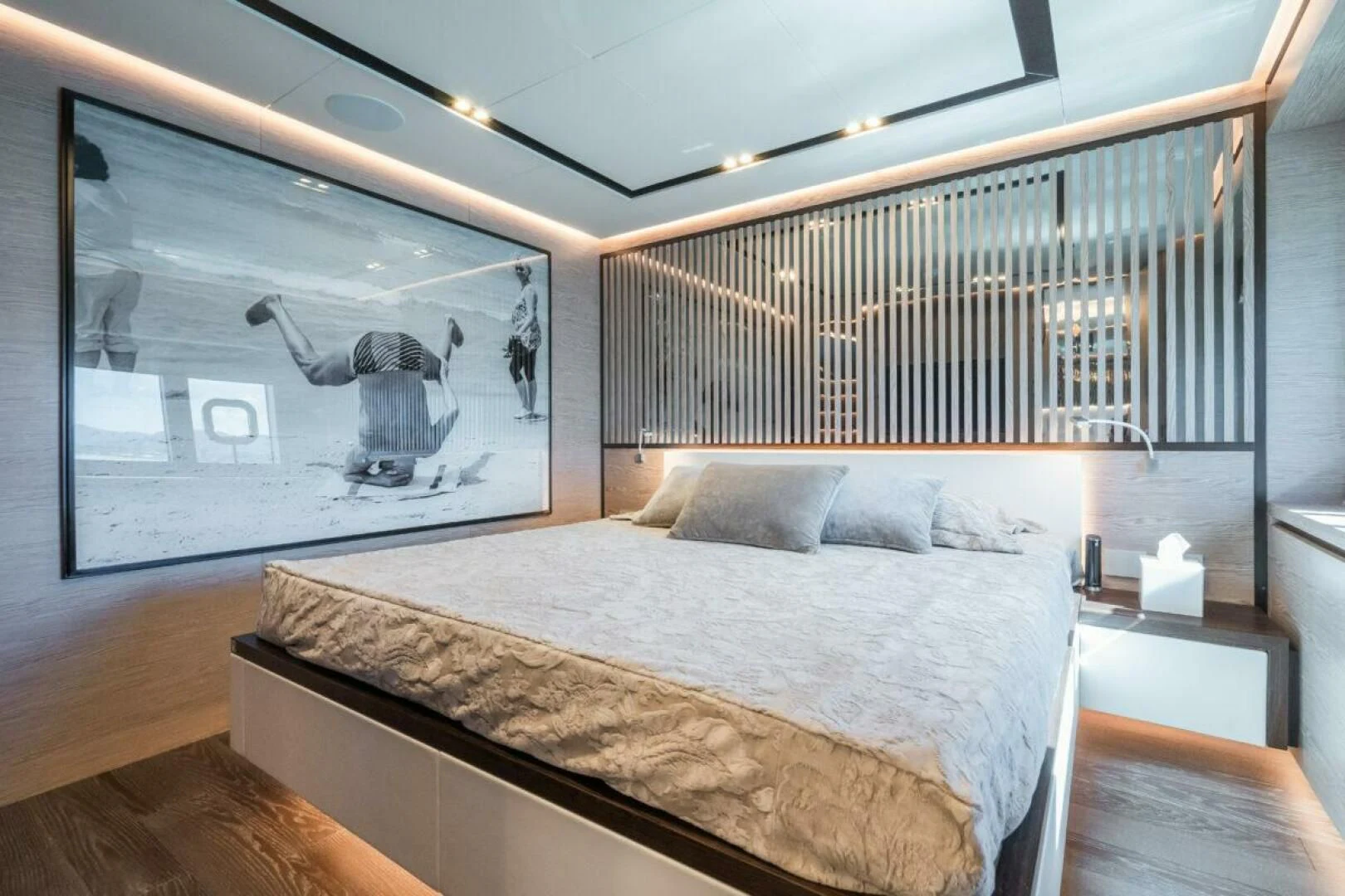 a bed with a large painting on the wall aboard ZOUT Yacht for Sale