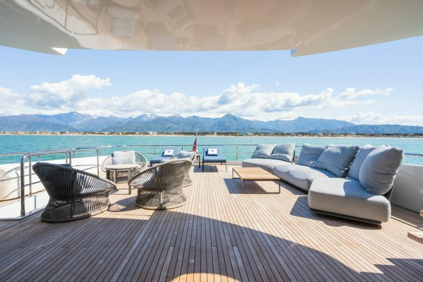 a patio with a view of the ocean and mountains in the background aboard ZOUT Yacht for Sale