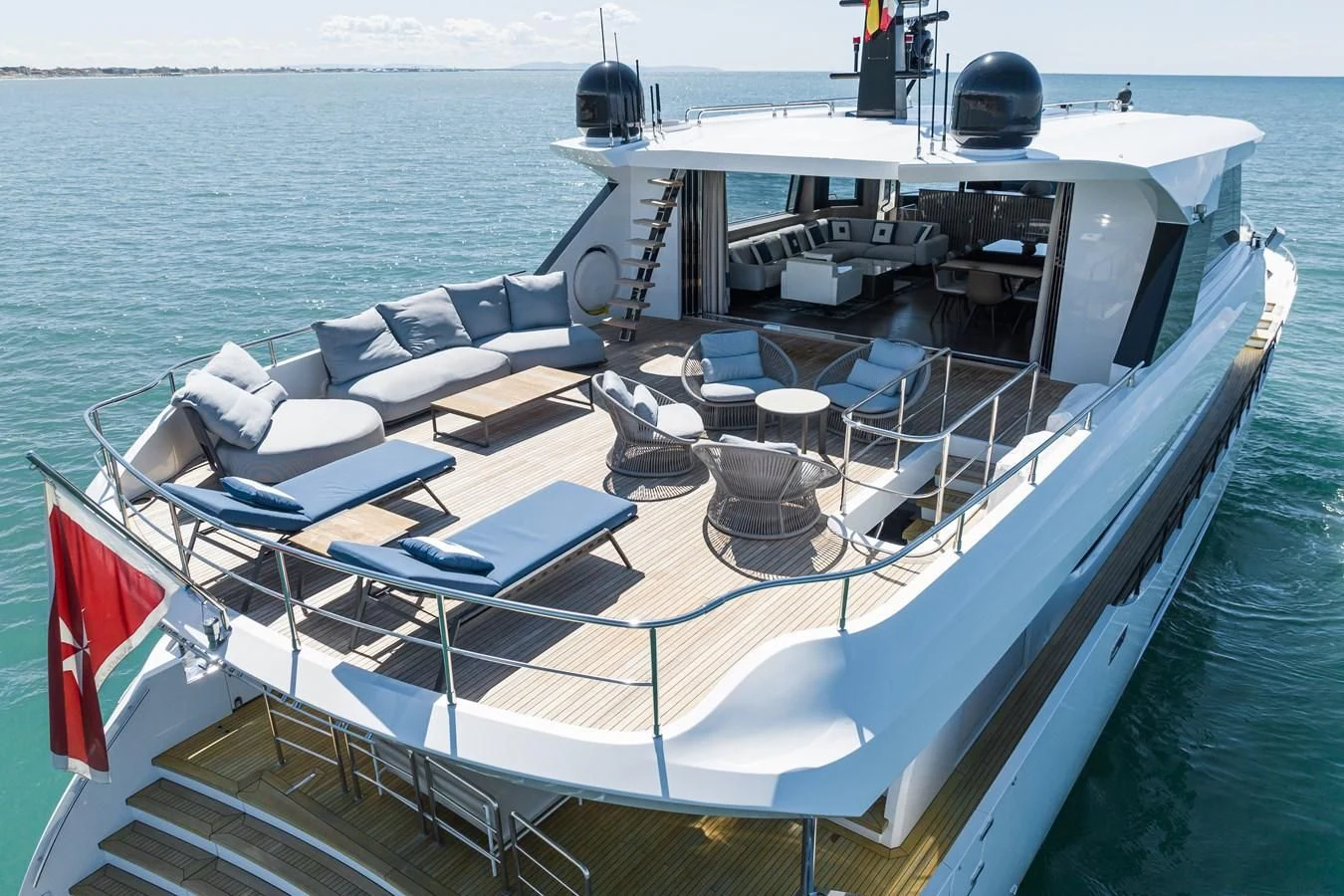 a boat with a flag on the deck aboard ZOUT Yacht for Sale