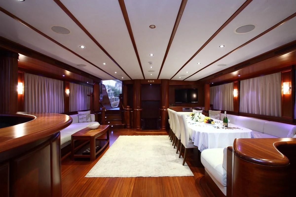 a room with tables and chairs aboard KAYA GUNERI V Yacht for Sale