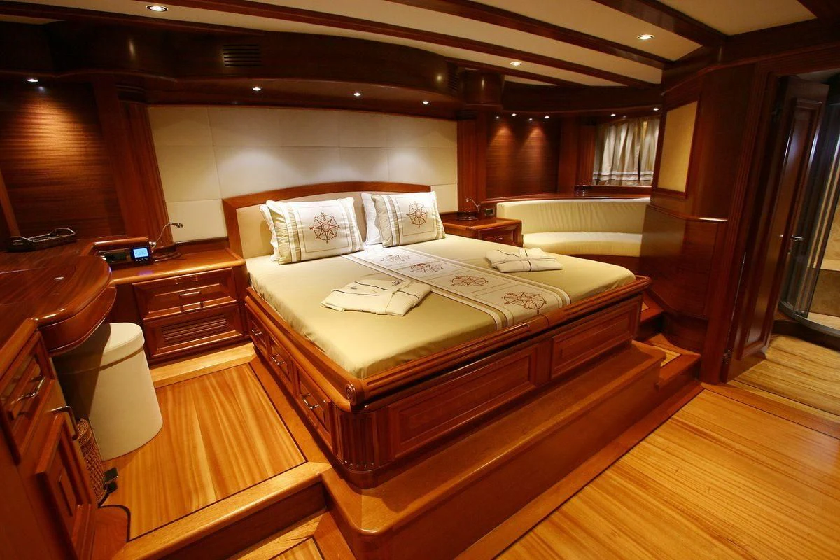 a room with a bed and a desk aboard KAYA GUNERI V Yacht for Sale