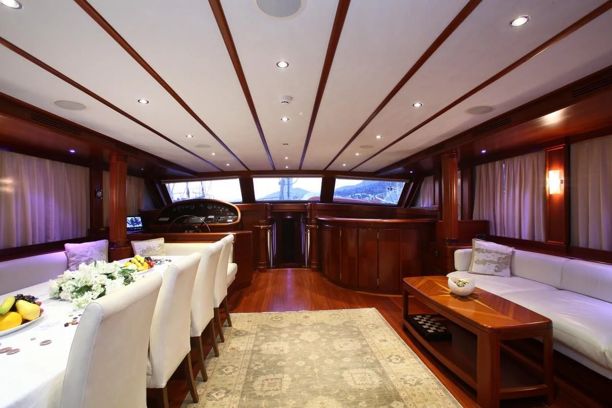 a room with tables and chairs aboard KAYA GUNERI V Yacht for Sale