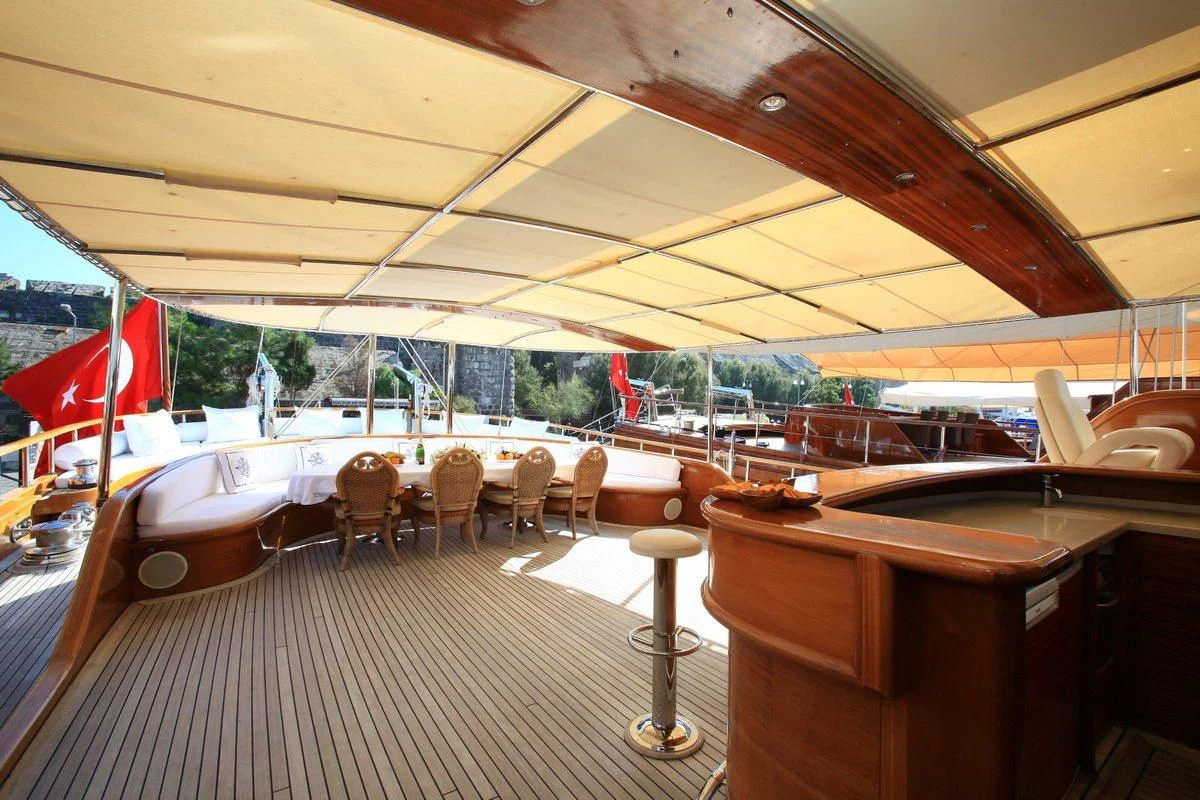 a room with a table chairs and a large window aboard KAYA GUNERI V Yacht for Sale