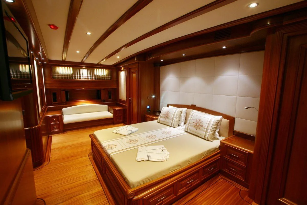 a room with a bed and a desk aboard KAYA GUNERI V Yacht for Sale