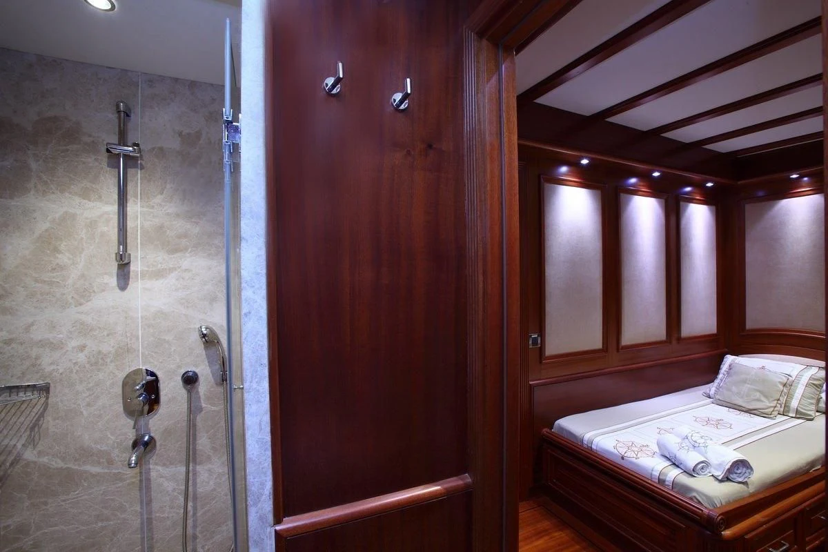 a bathroom with a bed and a shower aboard KAYA GUNERI V Yacht for Sale