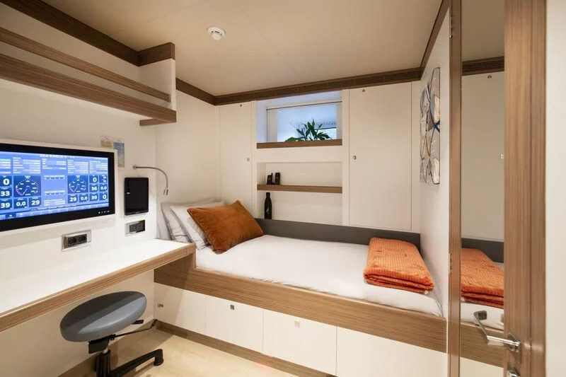 a bedroom with a bed and a tv aboard SEA EAGLE Yacht for Sale