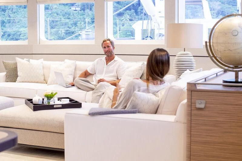 a man and a woman sitting on a couch aboard SEA EAGLE Yacht for Sale