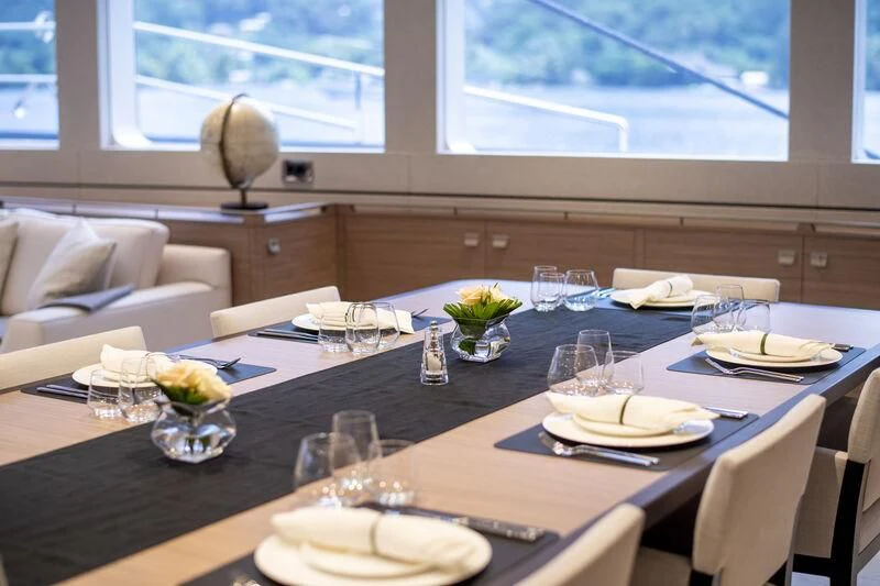 a dining table with plates and glasses aboard SEA EAGLE Yacht for Sale
