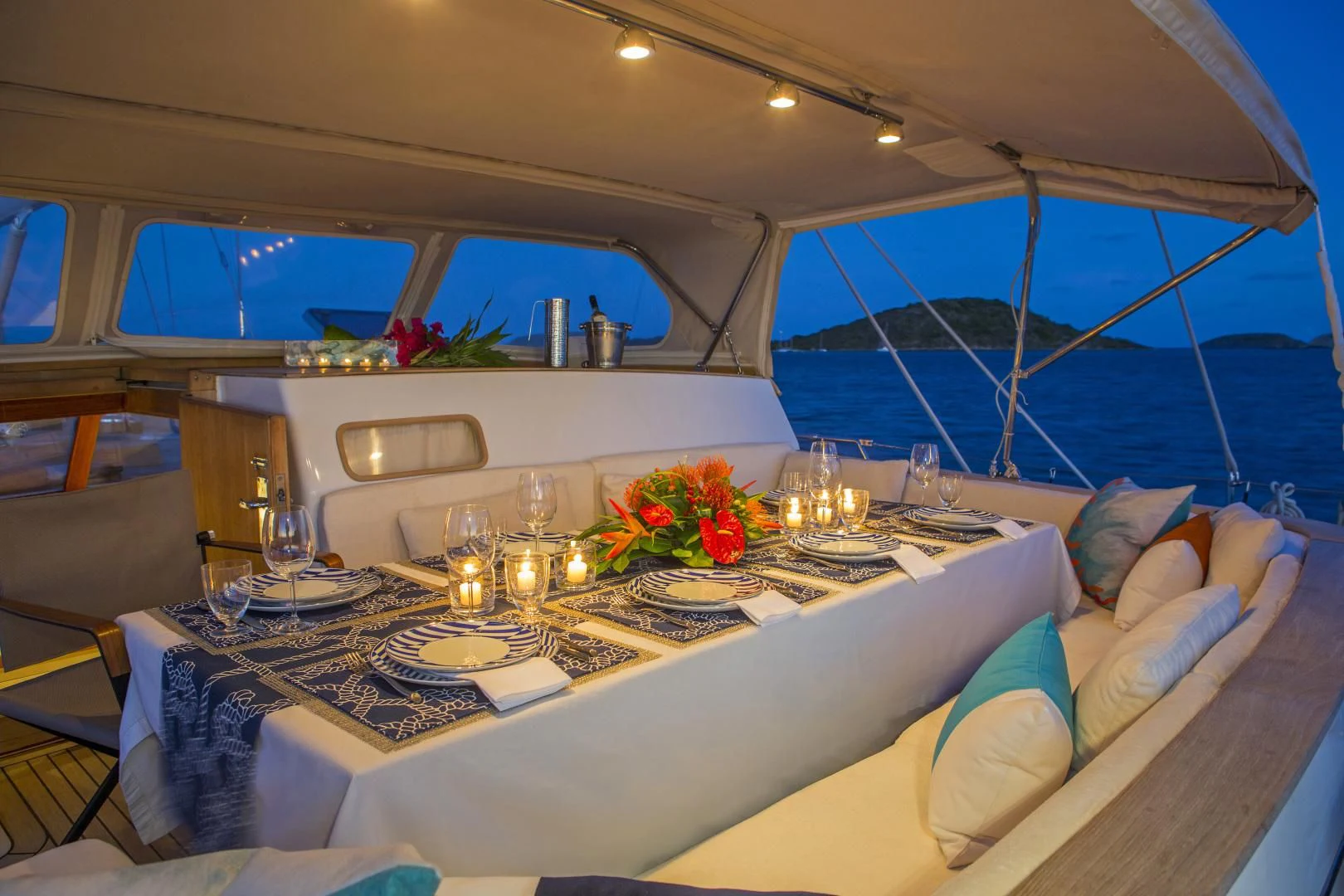 a table with wine glasses and a bed in a tent aboard WISDOM Yacht for Sale