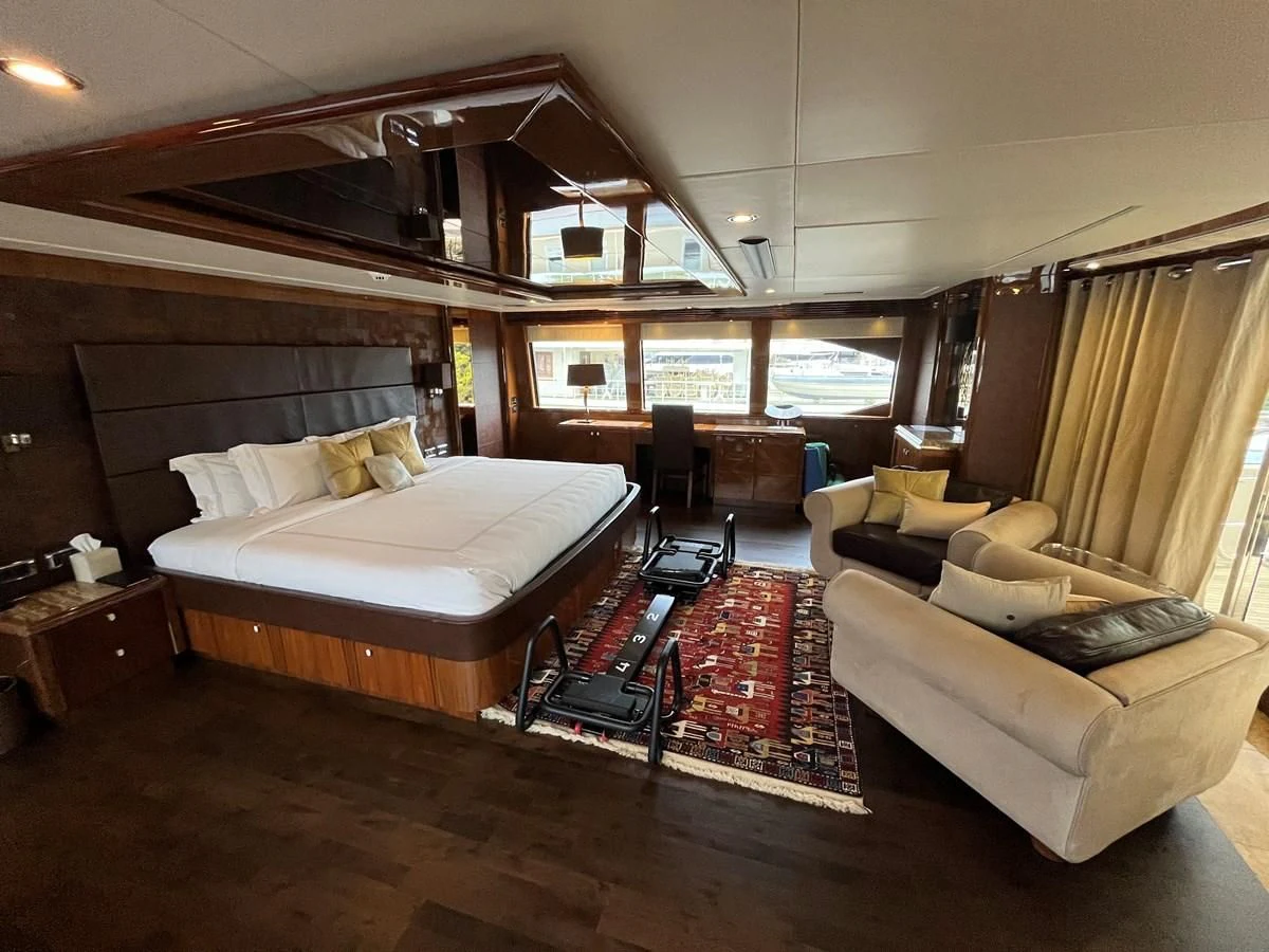 a bedroom with a bed and a couch aboard IMAN Yacht for Sale