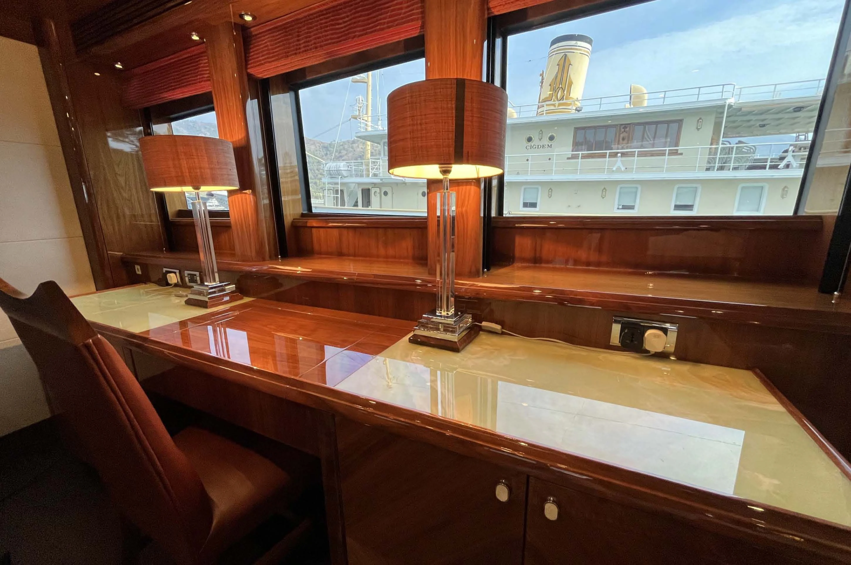 a large wooden table with a lamp on it aboard IMAN Yacht for Sale