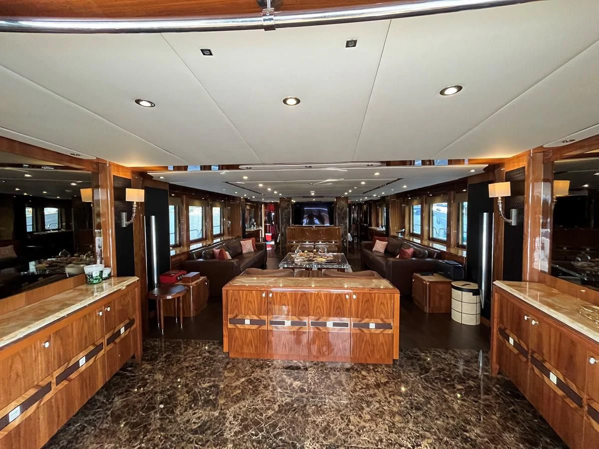 a large room with wood furniture aboard IMAN Yacht for Sale
