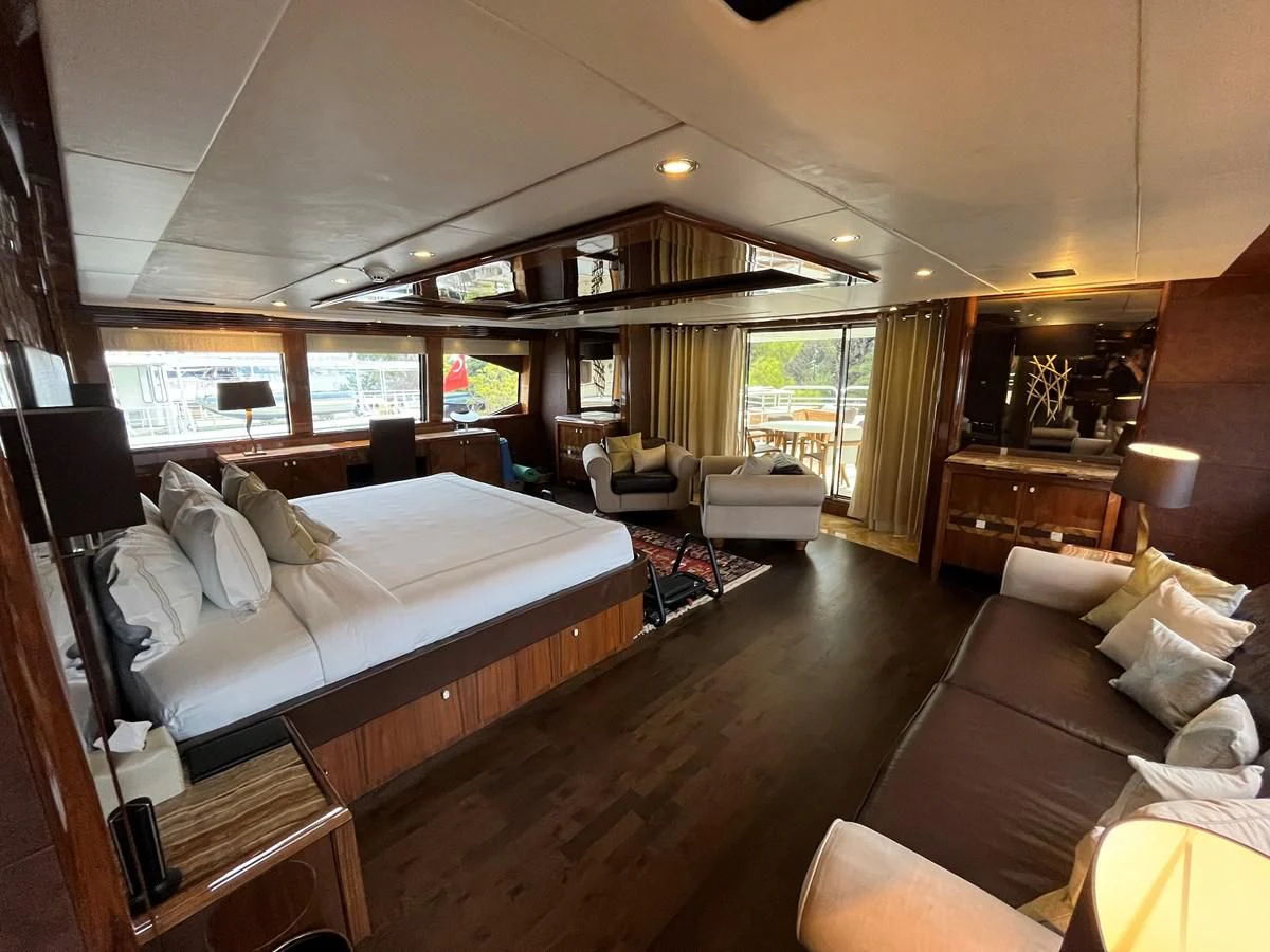 a bedroom with a bed and a couch aboard IMAN Yacht for Sale