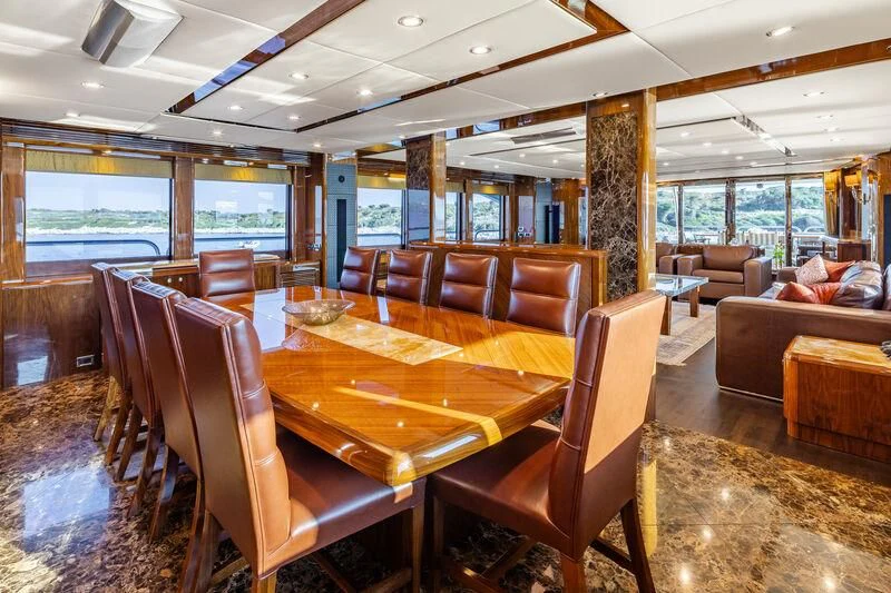 a large dining table in a living room aboard IMAN Yacht for Sale