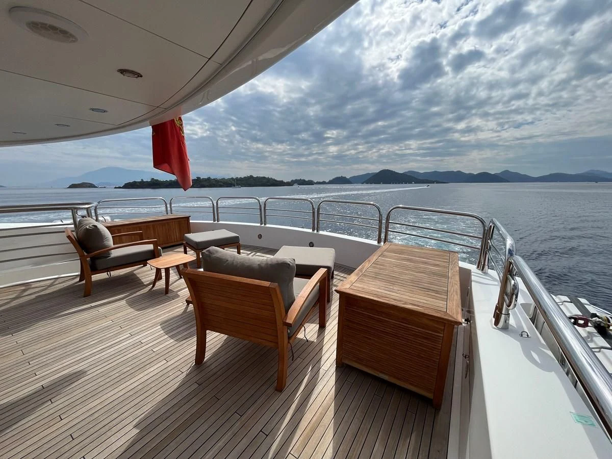 a deck with chairs and tables on it aboard IMAN Yacht for Sale