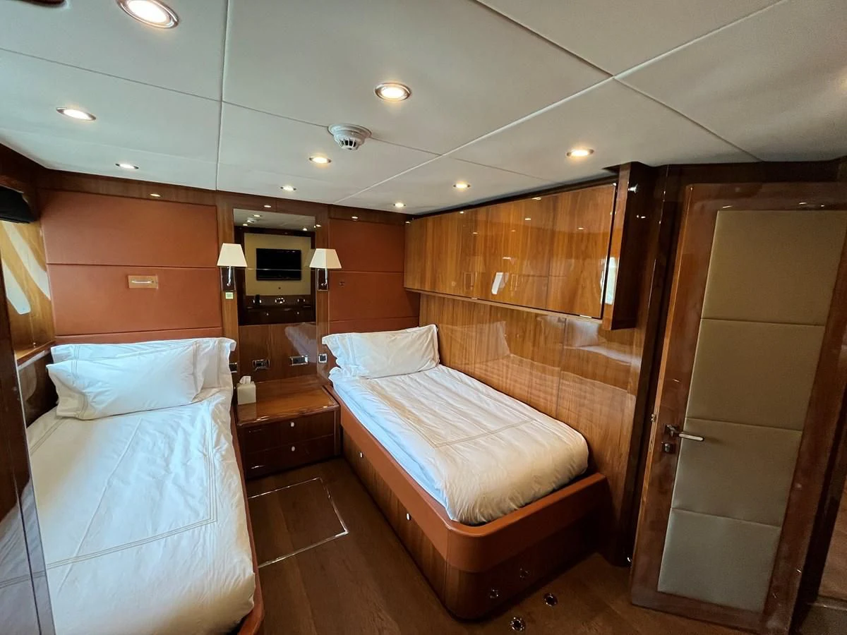 a room with a bed and a wood cabinet aboard IMAN Yacht for Sale