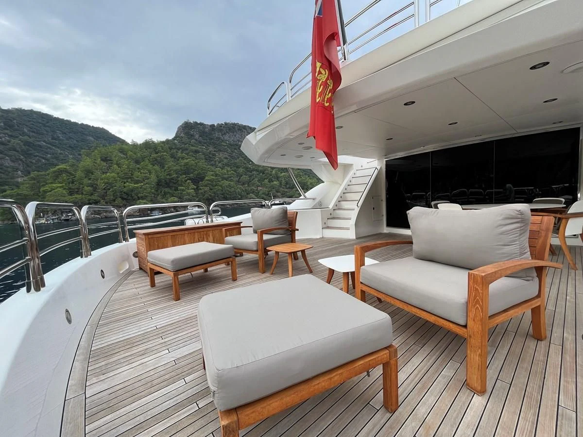 a deck with chairs and tables aboard IMAN Yacht for Sale