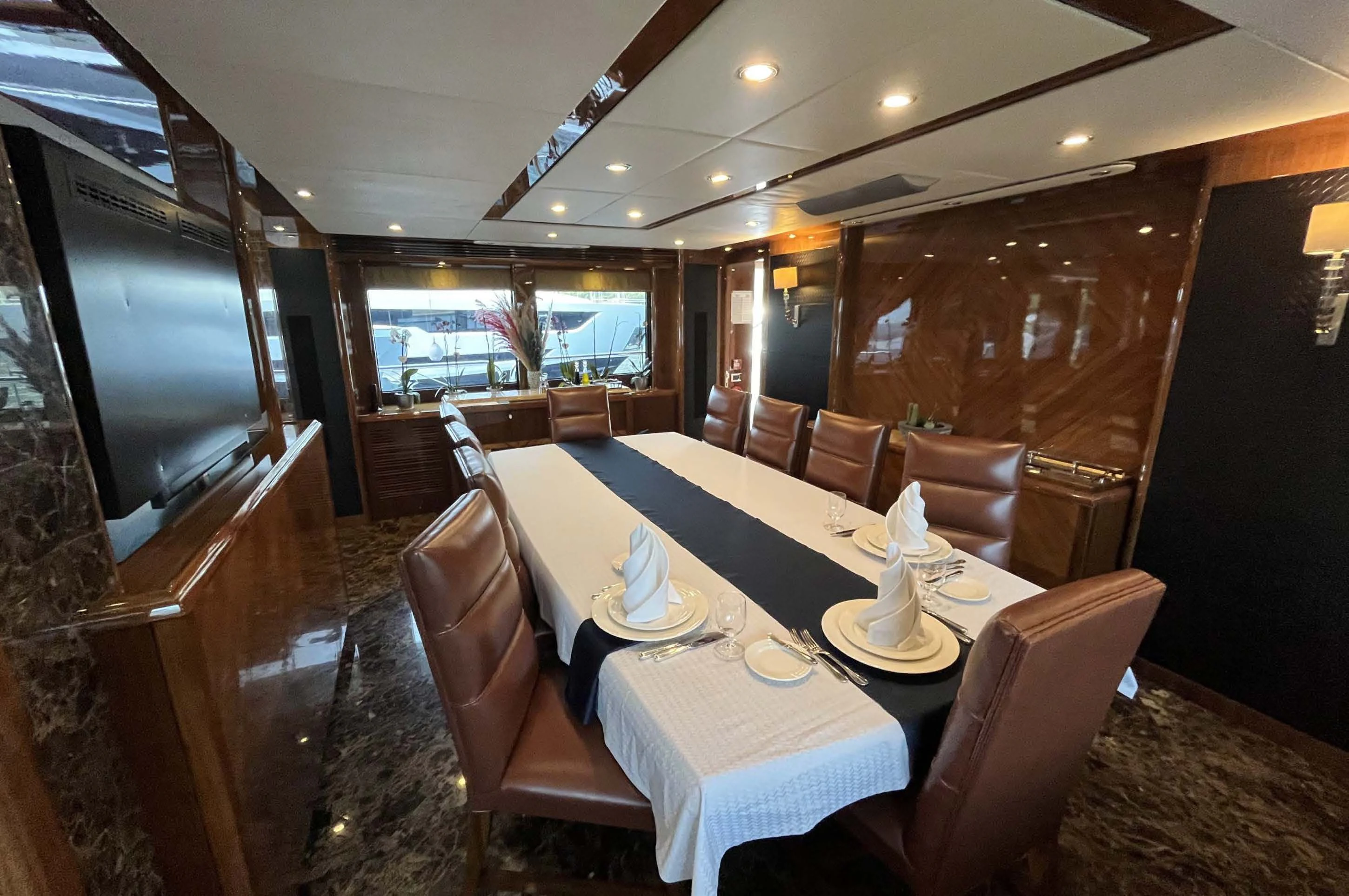 a dining room with a large screen aboard IMAN Yacht for Sale