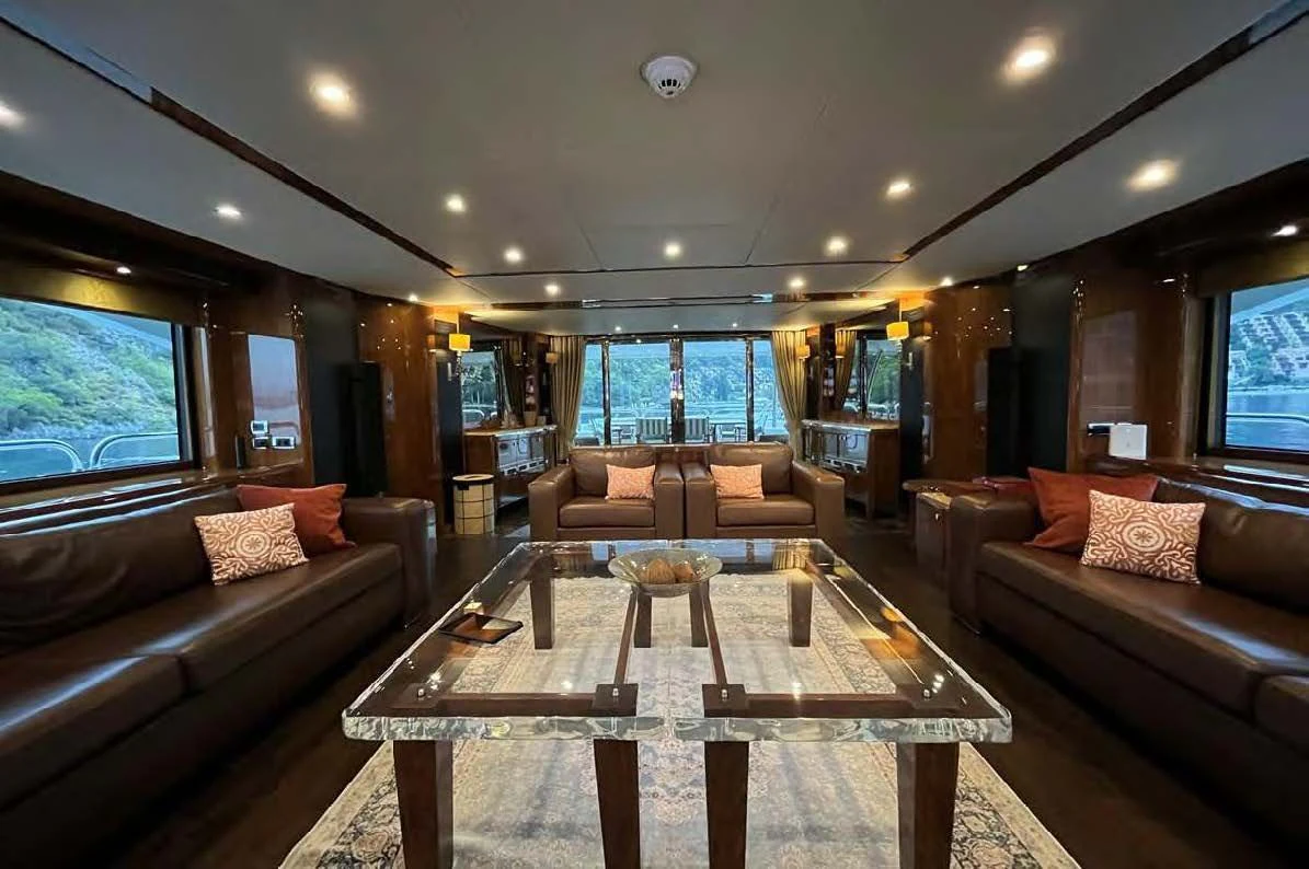 a living room with a large sofa and a table aboard IMAN Yacht for Sale