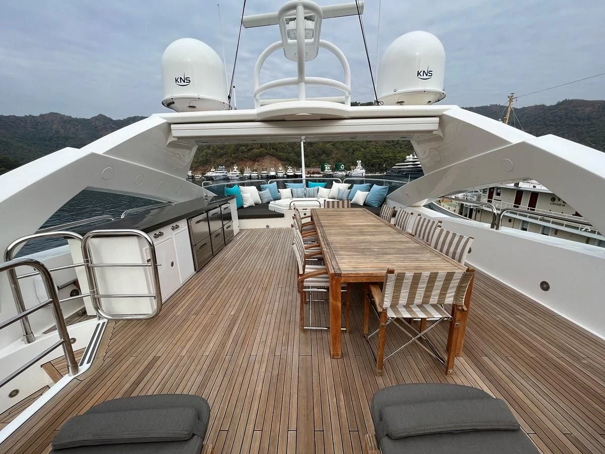 a deck with a table and chairs on it aboard IMAN Yacht for Sale