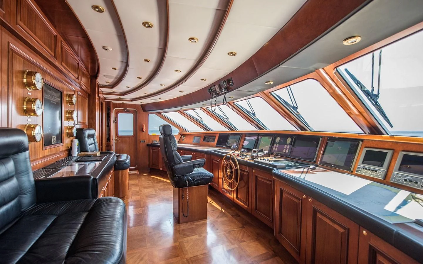 a large room with a piano and a leather chair aboard BLUE STAR Yacht for Sale