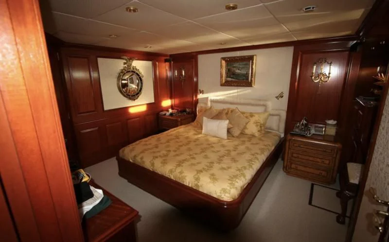 a bedroom with a bed and a desk aboard BLUE STAR Yacht for Sale