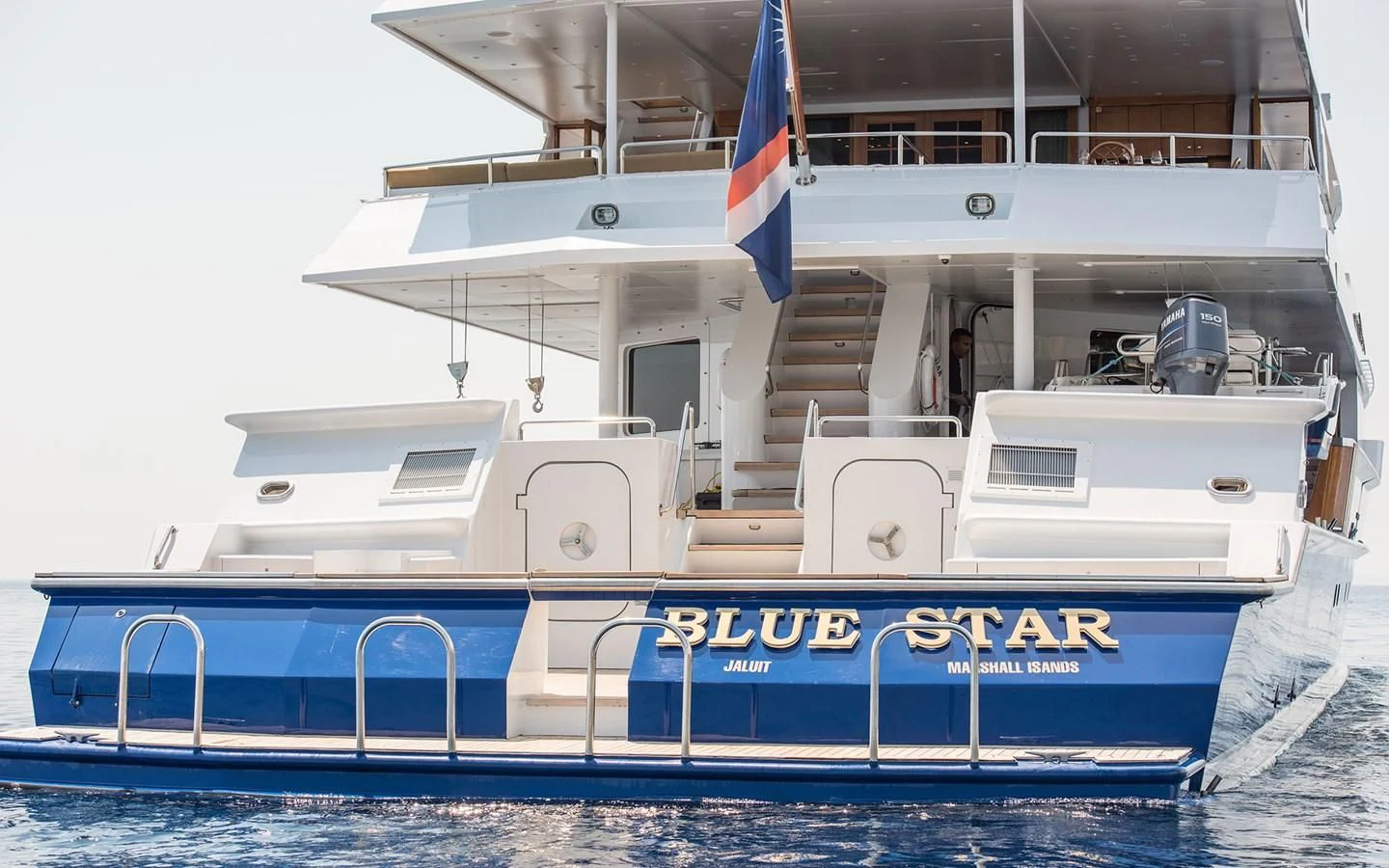 a boat with a flag on the deck aboard BLUE STAR Yacht for Sale