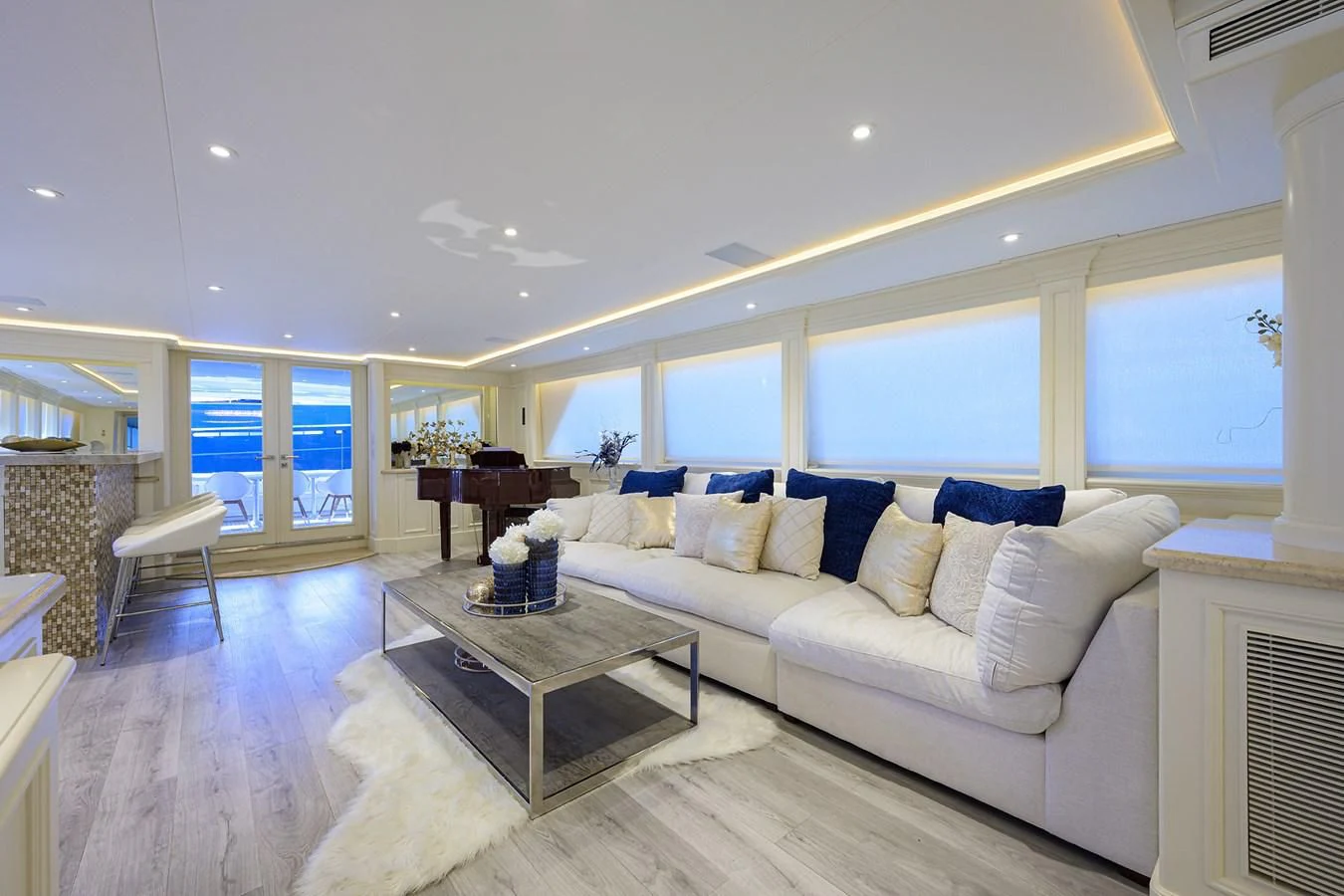 a living room with a large white couch and a large window aboard OCEAN DRIVE Yacht for Sale