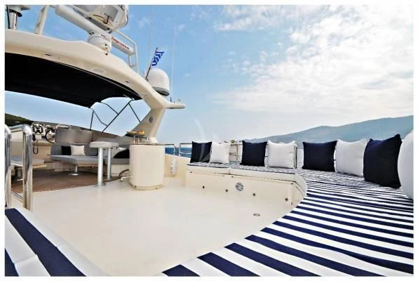 a large white bed with a white and blue striped bed spread aboard LADY CAROLA Yacht for Sale