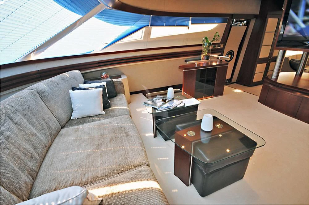 a couch and a coffee table in a room with a large window aboard LADY CAROLA Yacht for Sale