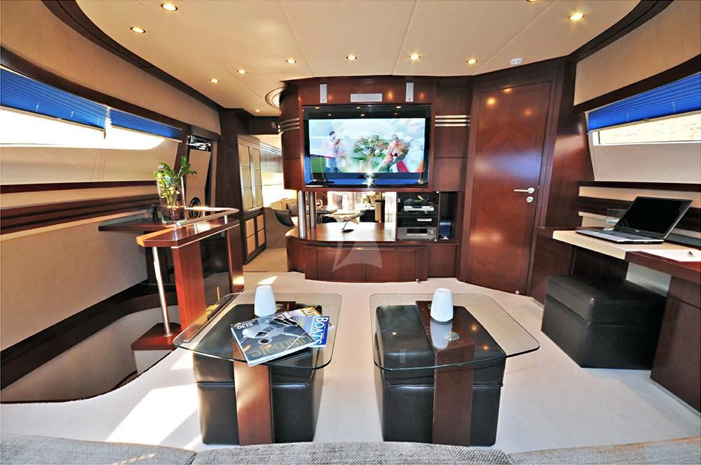 a living room with a tv and a table aboard LADY CAROLA Yacht for Sale