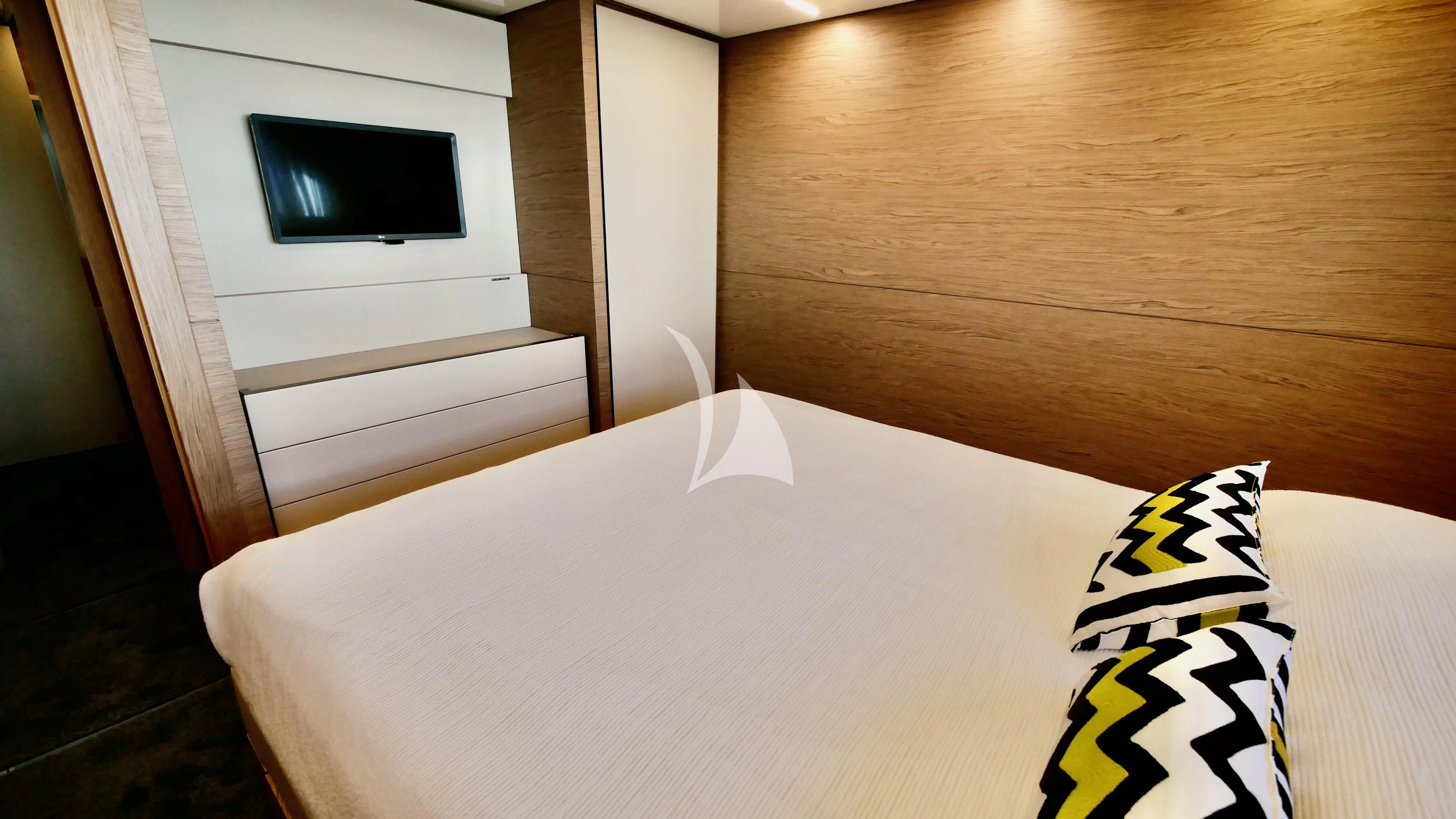 a bed with a white sheet and a yellow star on it aboard NINETEEN Yacht for Sale