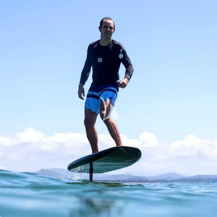 a person riding a surfboard aboard NINETEEN Yacht for Sale
