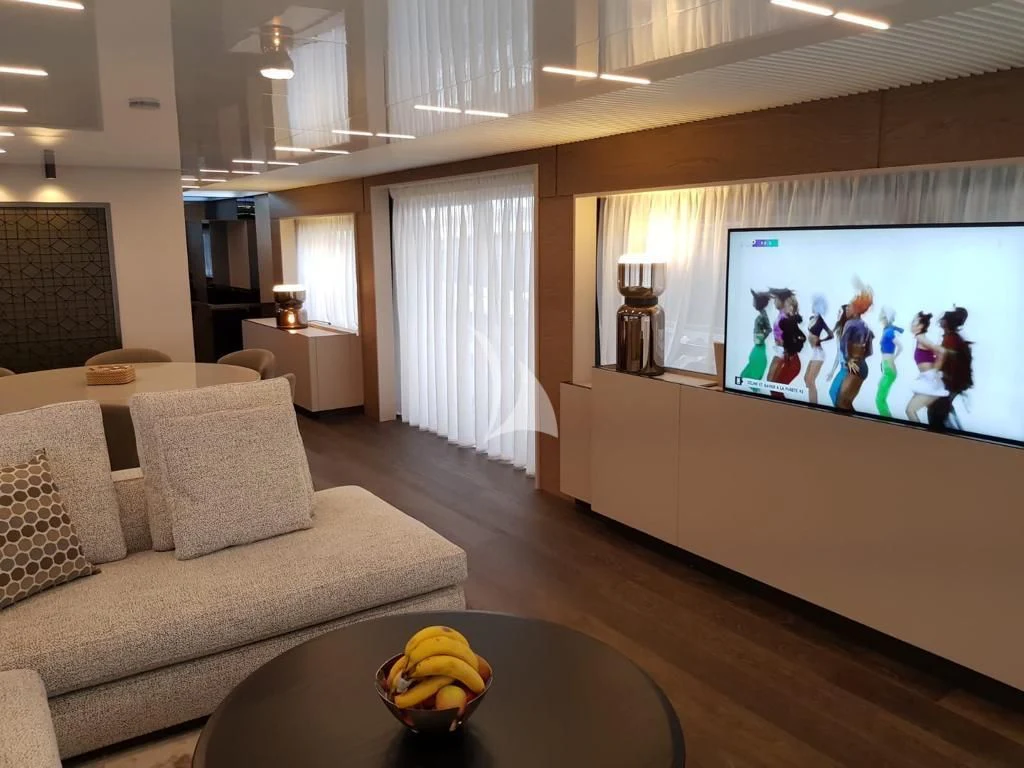 a living room with a large screen aboard NINETEEN Yacht for Sale