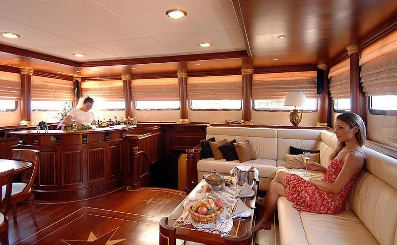 a person sitting on a couch in a large kitchen aboard MARE NOSTRUM Yacht for Sale