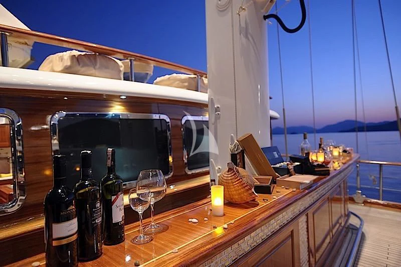 a table with wine bottles and glasses on it aboard MARE NOSTRUM Yacht for Sale