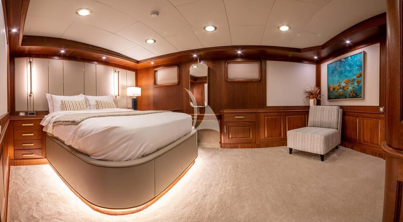 a large room with a bed and a chair aboard MARE NOSTRUM Yacht for Sale