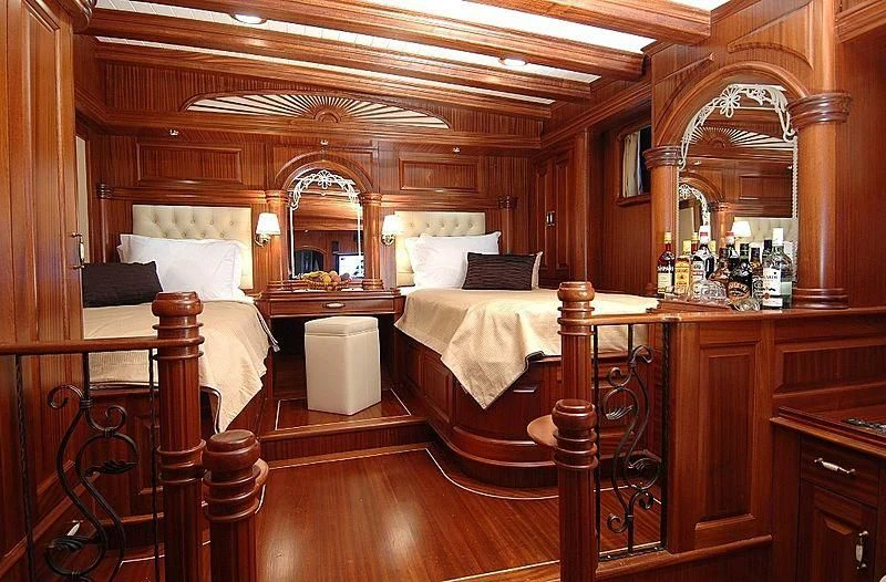 a room with wooden tables and beds aboard MARE NOSTRUM Yacht for Sale