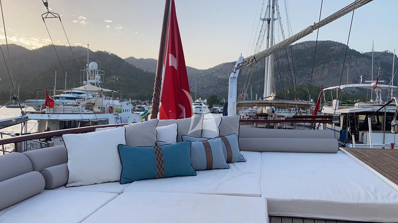 a large white bed with pillows on it next to a large sailboat aboard MARE NOSTRUM Yacht for Sale
