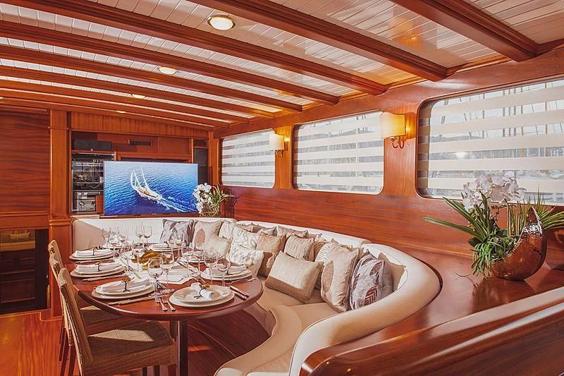 a dining table with chairs and a couch aboard HIC SALTA Yacht for Sale