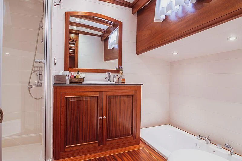 a bathroom with a tub sink and cabinets aboard HIC SALTA Yacht for Sale