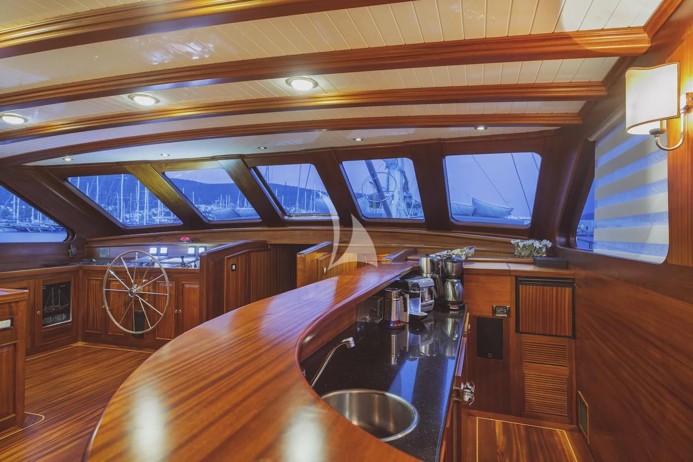a wooden bar with a large round table and a large window aboard HIC SALTA Yacht for Sale